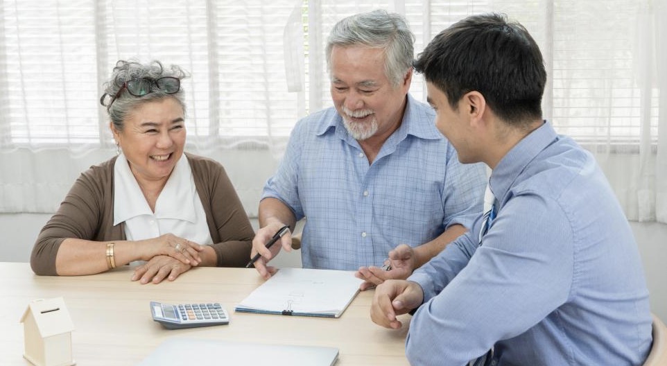 Older couple at table with papers and young man